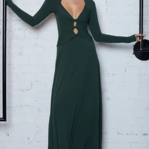 woman wearing a cut out green long dress with brown boots